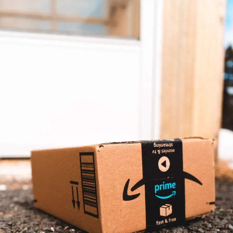 An Amazon Prime delivery box sitting on a doorstep, representing budget-friendly online shopping finds