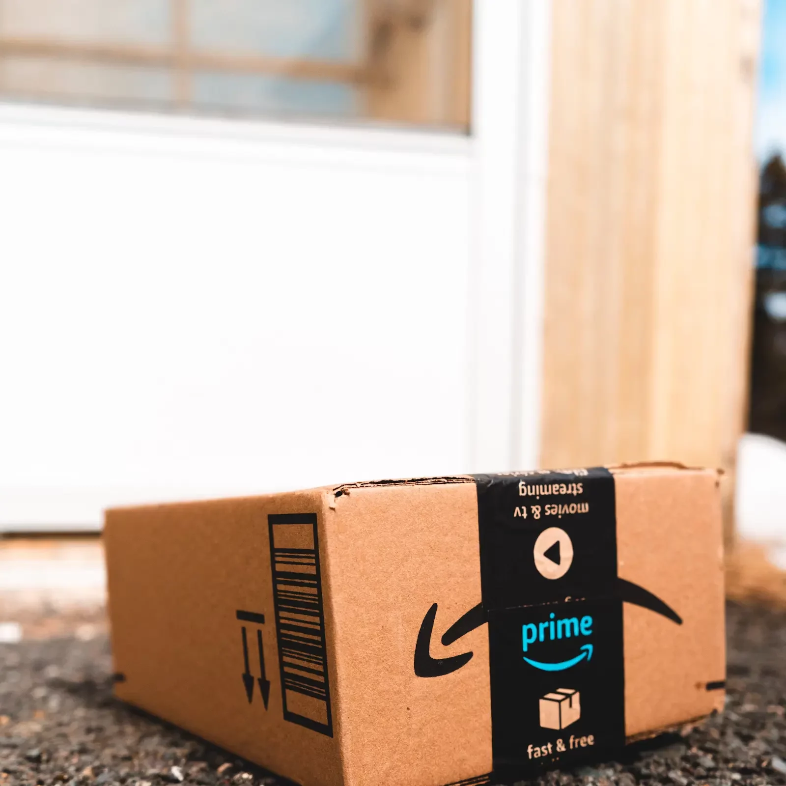 An Amazon Prime delivery box sitting on a doorstep, representing budget-friendly online shopping finds