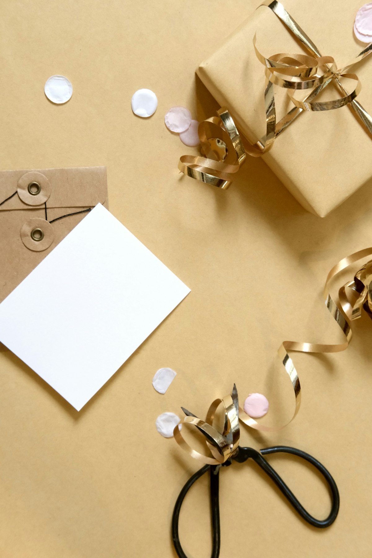 A wrapped gift box with ribbon, a card, and scattered confetti