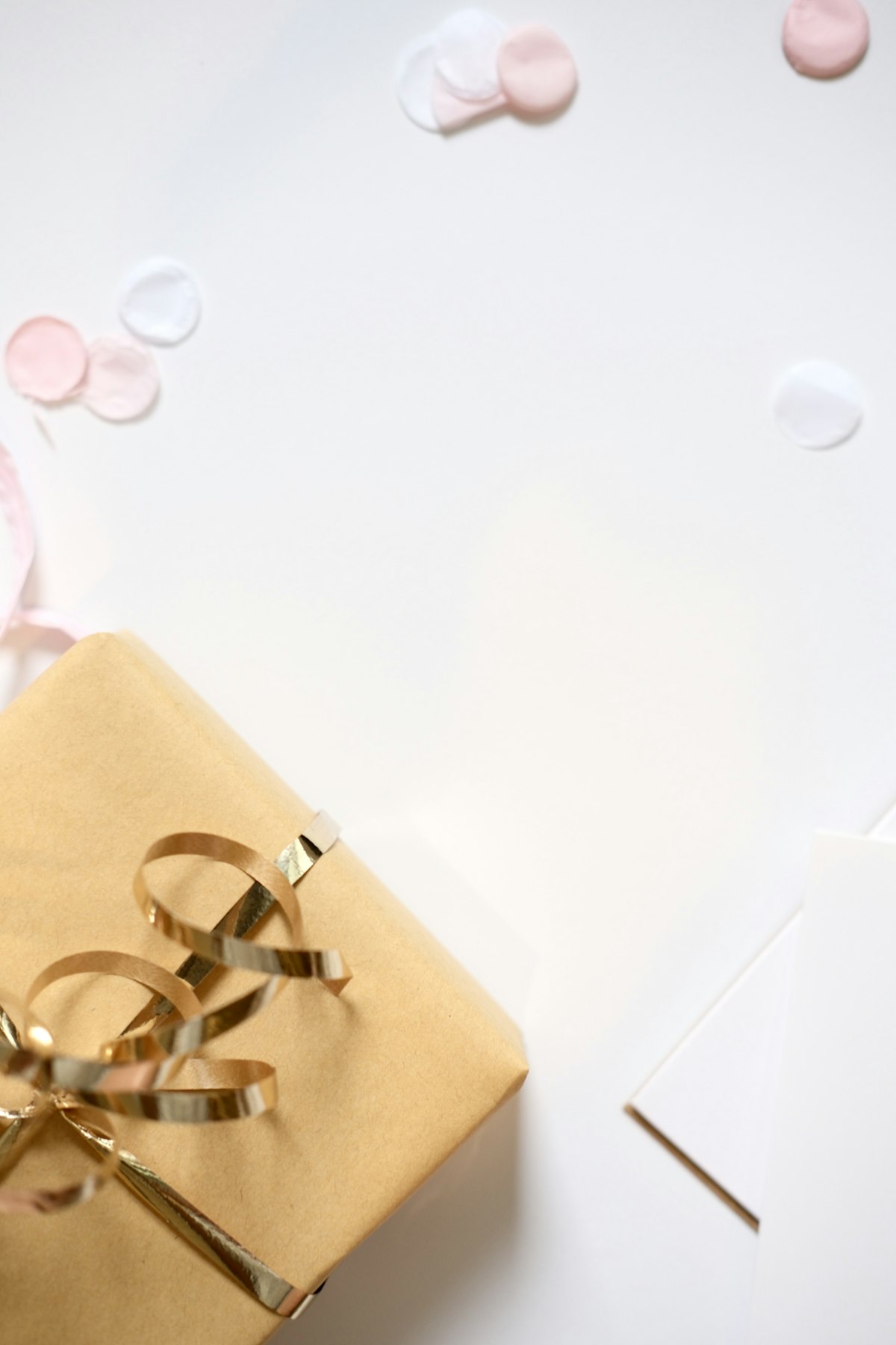 Elegant Gift Guide: a beautifully wrapped gift box with a gold ribbon and confetti