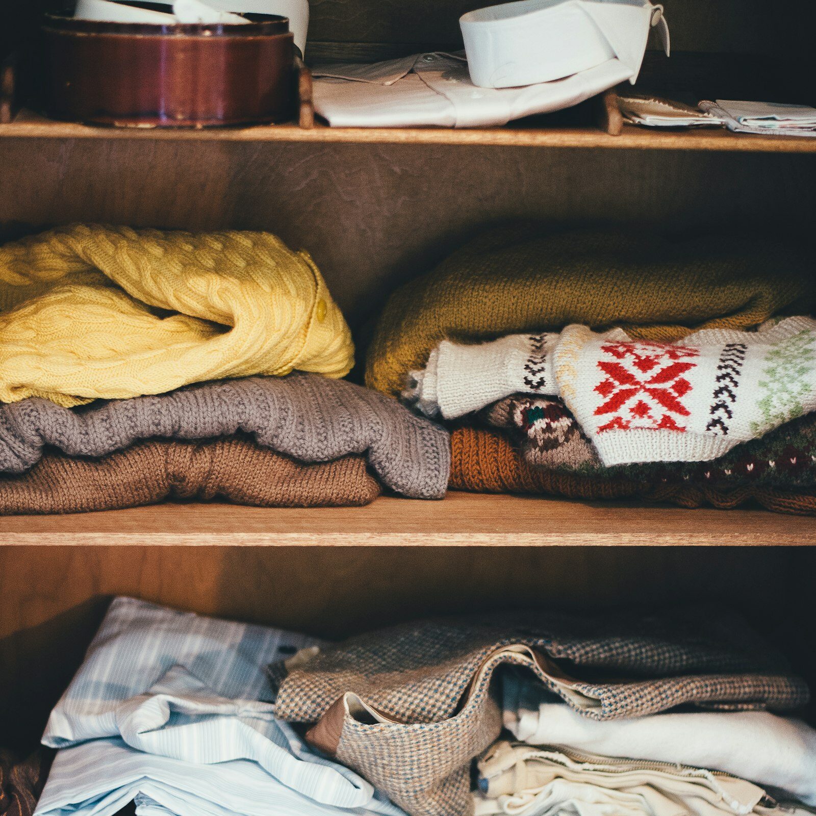 Home Storage Solutions: neatly organized closet shelves filled with folded clothes