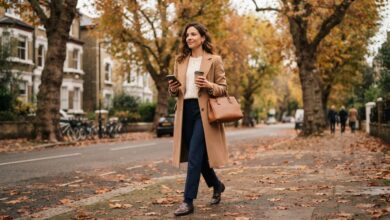 Old money style outfit: camel coat, cable-knit sweater, navy trousers and loafers